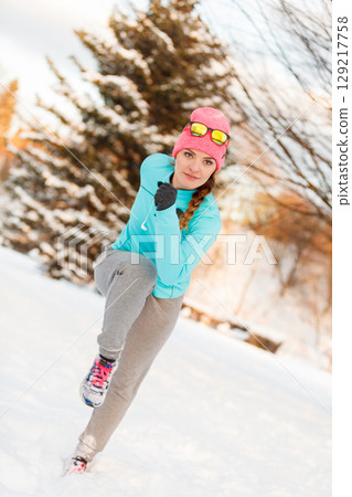 Woman exercising among snow and ice 129217758