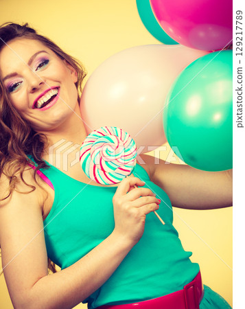 Woman with colorful balloons and lollipop Woman with colorful balloons and lollipop 129217789