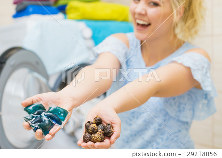 Woman holding laundry pods and washing nuts 129218056