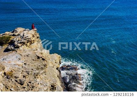 Tourist woman on sea cliffs in Spain Tourist woman on sea cliffs in Spain 129218116