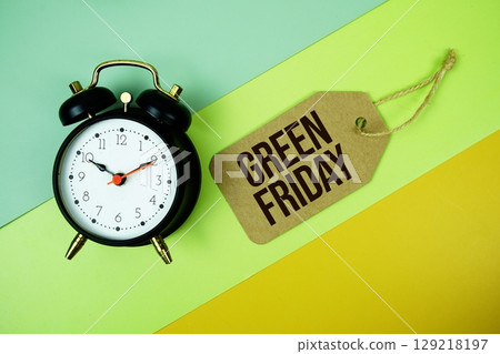 Green Friday text on price tag with alarm clock on yellow background 129218197