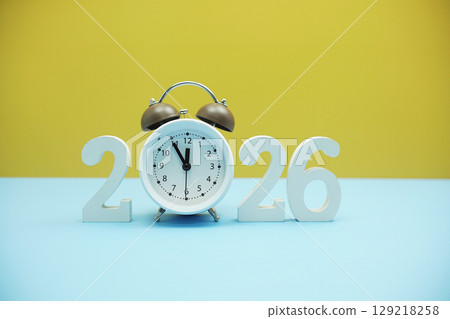 Happy new year 2026 and Alarm clock on blue and yellow background 129218258