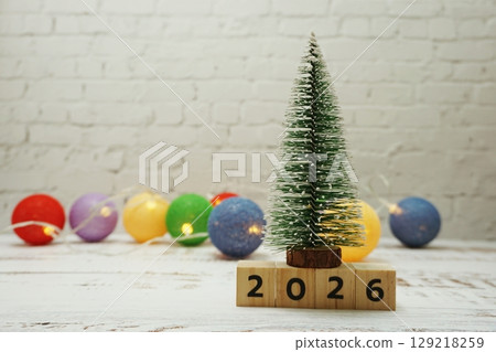 Happy New Year 2026 festive background with christmas tree on white brick wall background 129218259