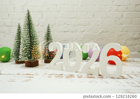 Happy New Year 2026 festive background with christmas tree on white brick wall background 129218260
