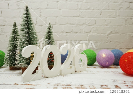 Happy New Year 2026 festive background with christmas tree on white brick wall background 129218261