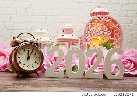 2026 Happy New Year with alarm clock with Roses and pink lantern Decoration on wooden background 2026 Happy New Year with alarm clock with Roses and pink lantern Decoration on wooden background 129218271