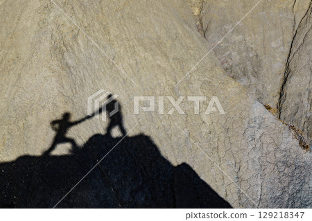 Shadow of two people on rock mountain Shadow of two people on rock mountain 129218347