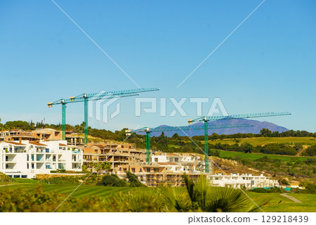 Spanish coast view with construction site with crane industrial equipment 129218439