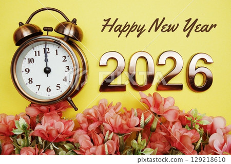 Happy New Year 2026 text with alarmclock and flower decoration on yellow background 129218610