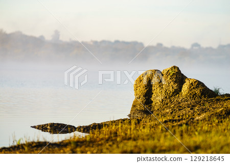 Morning fog over autumn lake water Morning fog over autumn lake water 129218645