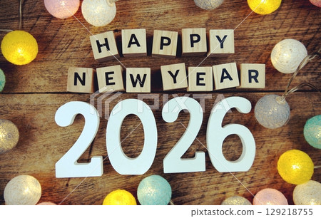 Happy New Year 2026 alphabet letters with LED cotton balls decoration on wooden background 129218755
