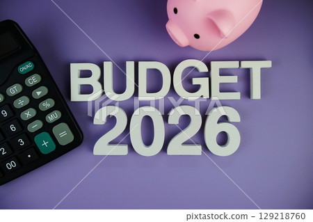 Budget 2026 alphabet letters with piggy bank and calculator top view on purple background Budget 2026 alphabet letters with piggy bank and calculator top view on purple background 129218760