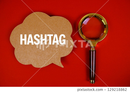 Hashtag text with speech bubble and magnifying glass on red background Hashtag text with speech bubble and magnifying glass on red background 129218862