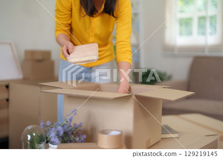 Asian Adult Woman Packing Belongings Cardboard Boxes Home Relocation Move Apartment Living Room Organizing House Property Moving Day Preparation Asian Adult Woman Packing Belongings Cardboard Boxes Home Relocation Move Apartment Living Room Organizing House Property Moving Day Preparation 129219145