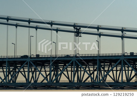 Blue sky and a car crossing an iron bridge Blue sky and a car crossing an iron bridge 129219250