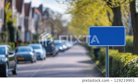 Blank Blue Street Sign on Quiet Residential Road with Parked Cars 129219901