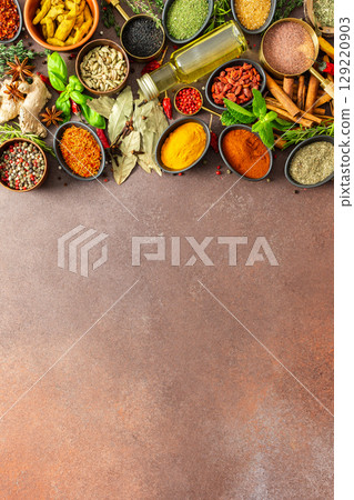 A colorful assortment of fragrant herbs and spices on a warm brown background, showcasing their visual variety and aromatic appeal 129220903