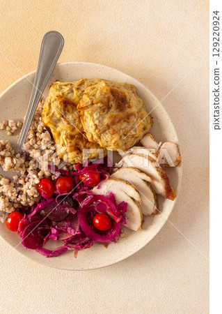 A wholesome plate featuring green buckwheat, chicken breast and zucchini pancakes paired with fermented vegetables A wholesome plate featuring green buckwheat, chicken breast and zucchini pancakes paired with fermented vegetables 129220924