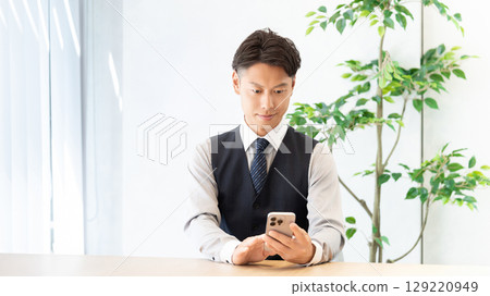 Male businessman using a smartphone Male businessman using a smartphone 129220949