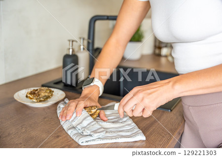 Female hands struggling to open a fresh oyster at home with a special oyster knife. Risks and challenges of handling shellfish without professional training Female hands struggling to open a fresh oyster at home with a special oyster knife. Risks and challenges of handling shellfish without professional training 129221303