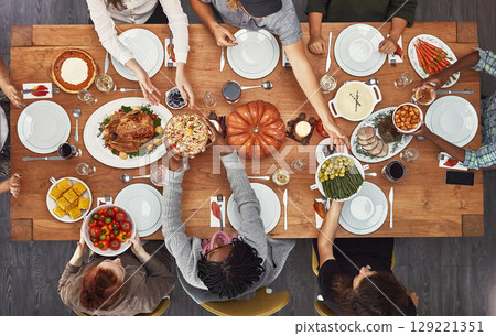 Top view, holiday dinner and thanksgiving table in social home, house or restaurant with festive food. Above, dining room or friends group with diversity, celebration or lunch with happiness together 129221351