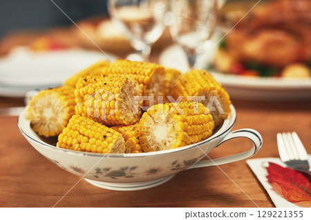 Corn, celebration and dinner on a table for Christmas, lunch and nutrition on holiday. Feast, Thanksgiving and food on a dining table for healthy eating, sharing and celebrate festive with a meal 129221355