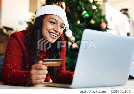 Woman, laptop and credit card in ecommerce for Christmas gift or online shopping with smile at home. Happy female banking online or shopping on computer for present during joyful festive season 129221365