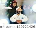 Christmas, bonding couple and surprise gift in house or home living room for holiday celebration, love or festive vacation. Smile, happy or xmas woman with present box in morning secret santa for man 129221426
