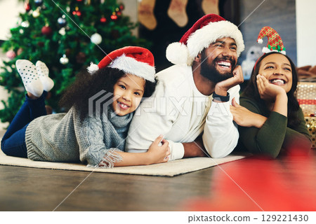 Happy family, mother and father with child for Christmas celebration while relaxing on living room floor at home. Mom, smile and young girl hugging her laughing dad enjoying quality time for bonding 129221430