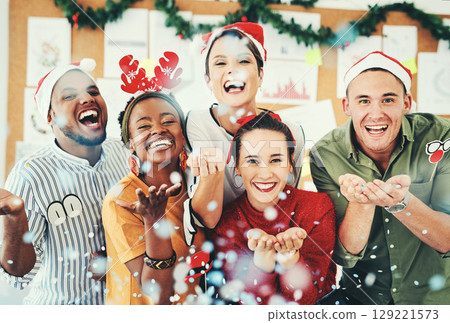 Christmas, office and business people blowing confetti and having fun together. Portrait, xmas party or group of happy employees, workers or coworkers celebrating with paper decorations in workplace 129221573