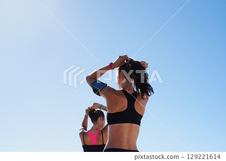 Fitness women, blue sky background and hair tie for cardio exercise, running workout and summer wellness. Healthy female runners, sports athlete and friends prepare for morning training on sky mockup Fitness women, blue sky background and hair tie for cardio exercise, running workout and summer wellness. Healthy female runners, sports athlete and friends prepare for morning training on sky mockup 129221614