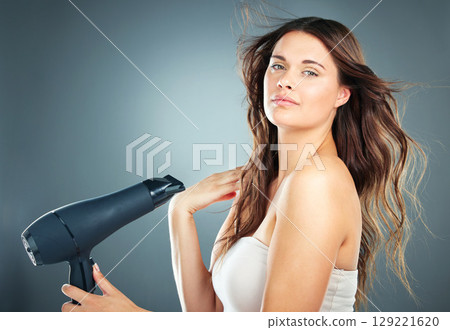 Portrait, hair care and blow dryer for woman, salon natural beauty and confident on studio background. Female, girl and equipment for spa styling, casual and trendy look for aesthetic hair style 129221620