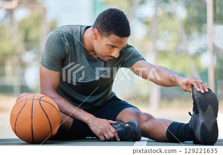 Basketball, leg stretching and fitness of a man before exercise, training and outdoor workout. Health, wellness and game start of a athlete on a basketball court on the ground prepare with warm up Basketball, leg stretching and fitness of a man before exercise, training and outdoor workout. Health, wellness and game start of a athlete on a basketball court on the ground prepare with warm up 129221635