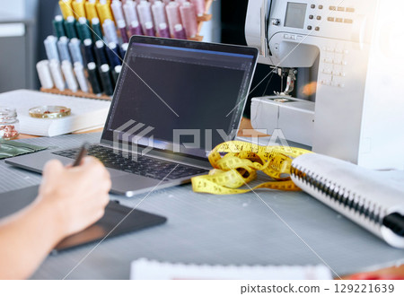 Fashion, designer and laptop for a sketch or drawing for clothes manufacturing in a tailor workshop or factory for creative ideas. Hand of woman at desk with design technology for illustration work 129221639