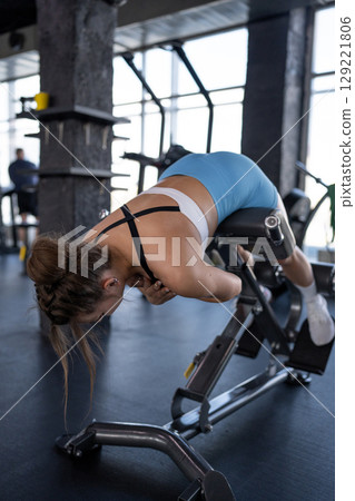 An Energetic Woman Engaged in a Rigorous Fitness Exercise in a Modern Gym Setting 129221806