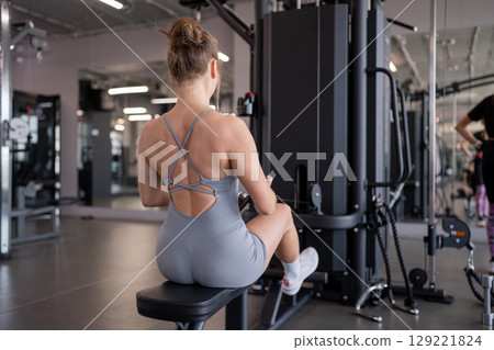 Focused on Back exercises sporty woman. Fitness Engaging in Strength Training Activities at the Gym for Optimal Results. Focused on Back exercises sporty woman. Fitness Engaging in Strength Training Activities at the Gym for Optimal Results. 129221824