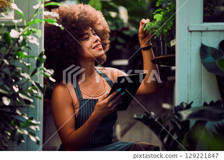 Tablet, plants and black woman, small business owner and greenhouse environment in retail flowers shop, store and eco friendly market. Happy gardening worker, digital planning and sustainable growth Tablet, plants and black woman, small business owner and greenhouse environment in retail flowers shop, store and eco friendly market. Happy gardening worker, digital planning and sustainable growth 129221847