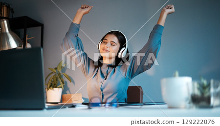 Woman, night and dance with headphones for music, stress relief or relax singing along alone at home. Female freelancer relaxing, listening or enjoying audio sound track and dancing by workspace desk 129222076
