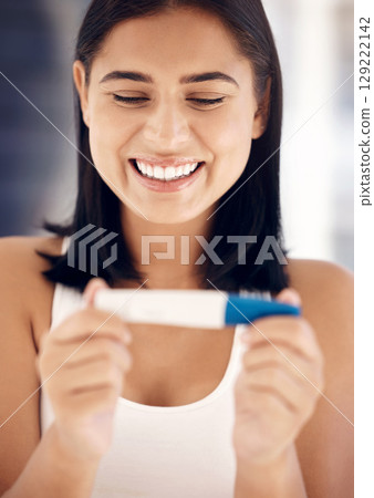 Pregnancy test, happy and smile with a woman reading the results after testing with a home kit in her bathroom. Wow, pregnant and fertility treatment with a female mother to be feeling excited 129222142