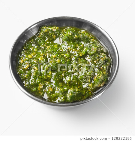 Fresh pesto sauce with olive oil in a small bowl on white background Fresh pesto sauce with olive oil in a small bowl on white background 129222195