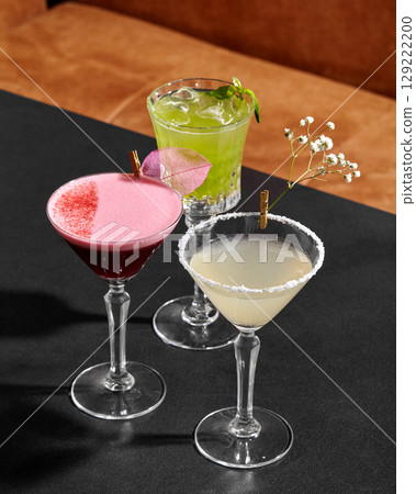 Bartender preparing colorful cocktails on bar counter 129222200