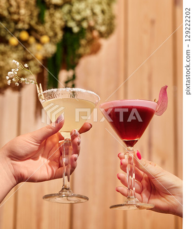 Two female bartenders holding cocktails in martini glasses 129222202