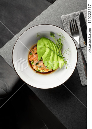 Salmon tartare with avocado and soy sauce dressing on elegant restaurant table Salmon tartare with avocado and soy sauce dressing on elegant restaurant table 129222217