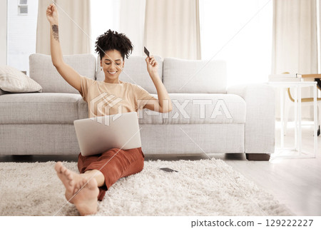 Black woman, laptop and happy with credit card, ecommerce and approved loan in lounge. Young female, lady and digital device for success, online banking and happiness with smile, joy and living room. Black woman, laptop and happy with credit card, ecommerce and approved loan in lounge. Young female, lady and digital device for success, online banking and happiness with smile, joy and living room. 129222227