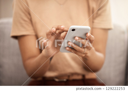 Hands, phone and woman typing on sofa in home living room, texting or scrolling social media. Tech, relax and female on couch in lounge on mobile smartphone networking or internet browsing in house. Hands, phone and woman typing on sofa in home living room, texting or scrolling social media. Tech, relax and female on couch in lounge on mobile smartphone networking or internet browsing in house. 129222253
