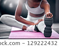 Fitness, gym and black woman stretching legs on floor mat for wellness, health and body warm up. Healthy, exercise and athlete girl leg preparation for training, wellbeing and workout. 129222432