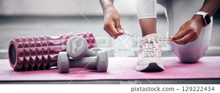 Fitness, weights and woman tying shoes before workout in gym for health, wellness and strength. Sports, training and closeup of athlete with laces to tie while preparing to exercise in a sport center Fitness, weights and woman tying shoes before workout in gym for health, wellness and strength. Sports, training and closeup of athlete with laces to tie while preparing to exercise in a sport center 129222434