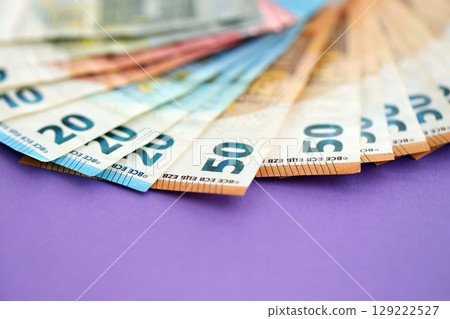 Big amount of european euro currency money notes on purple color table close up 129222527