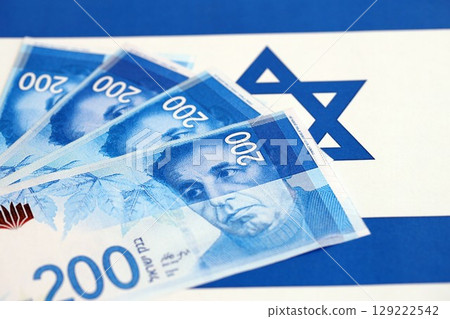 Israel New Shekels banknotes on national flag. The current Israel money bills lies on flag 129222542