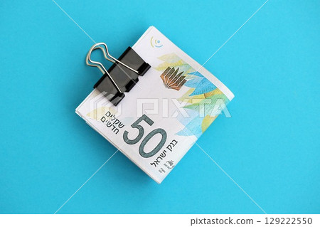 Israel New Shekels banknotes on blue background. The current Israel money bills lies on blue 129222550